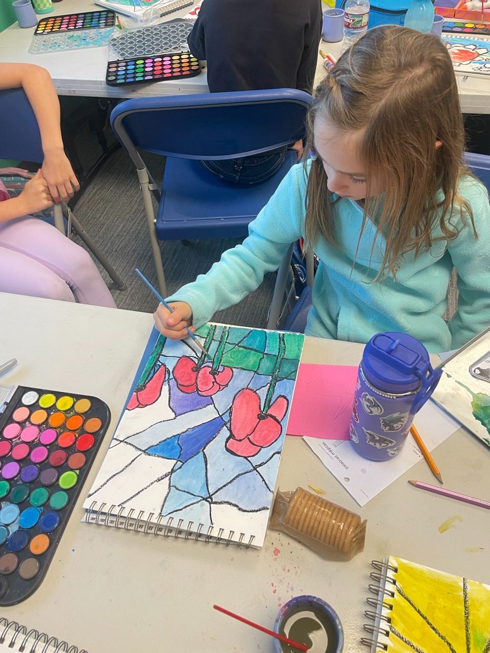 A child painting a stained-glass-style watercolor of flowers
