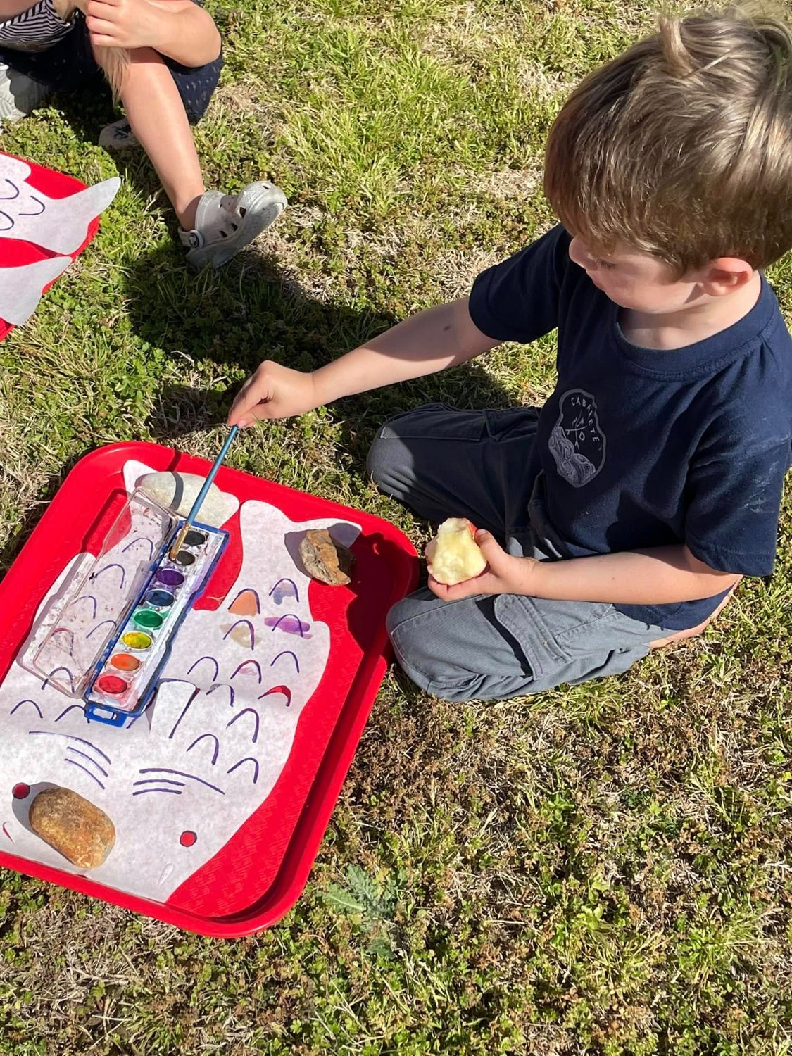 A child painting with a brush at a table
