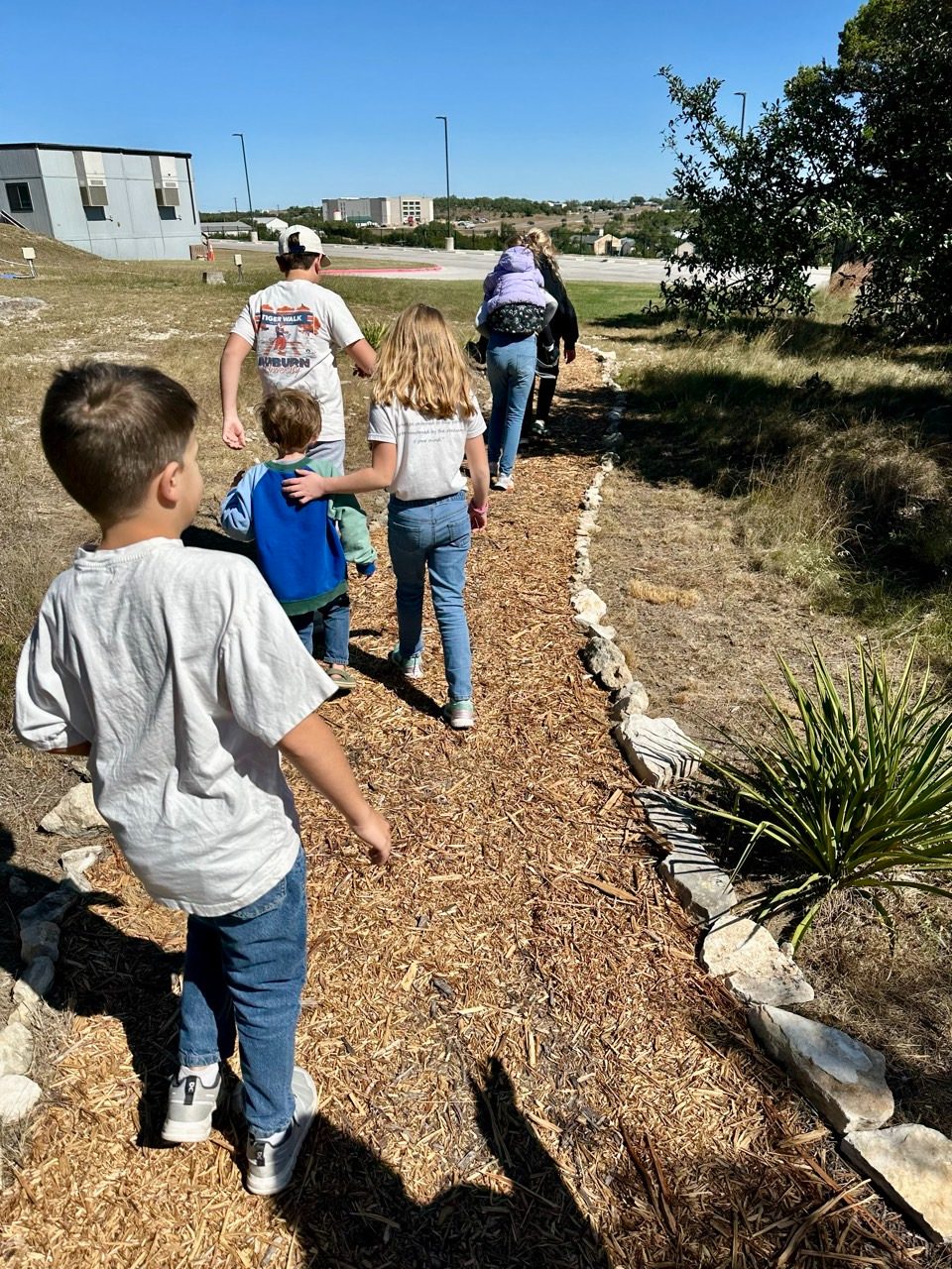 Children walking a nature path together in the Hill Country